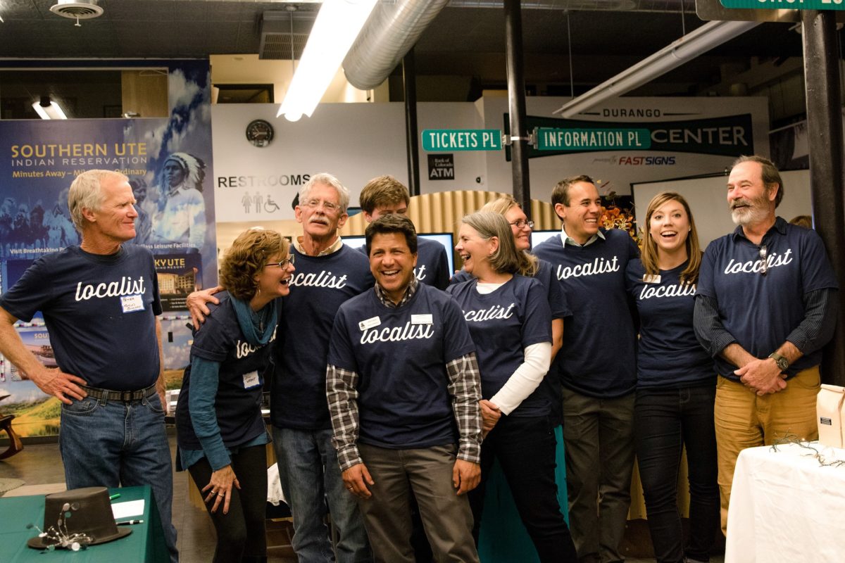 Localist-1166 A candid photo of eight people standing in a row all wearing t-shirts that read "Localist".