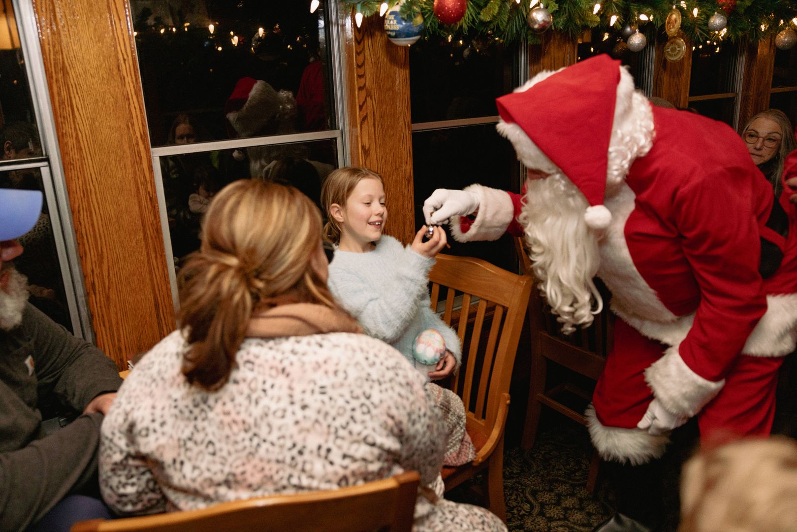 Santa giving young child a bell.