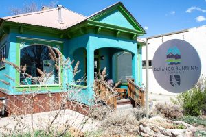 A blue building with signage out front reading "Durango Running Company"