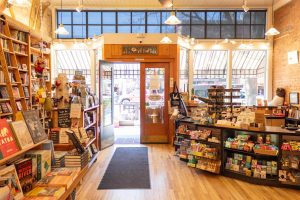 A photograph of the inside of a building with books on the left side and a cashier on the right.