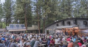 People sitting at picnic tables watching a western concert.