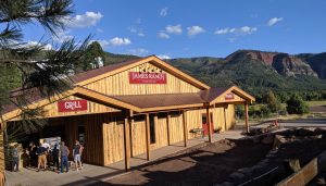 A photo of an outside of a wooden building with signage reading "James Ranch Market" and "Grill"